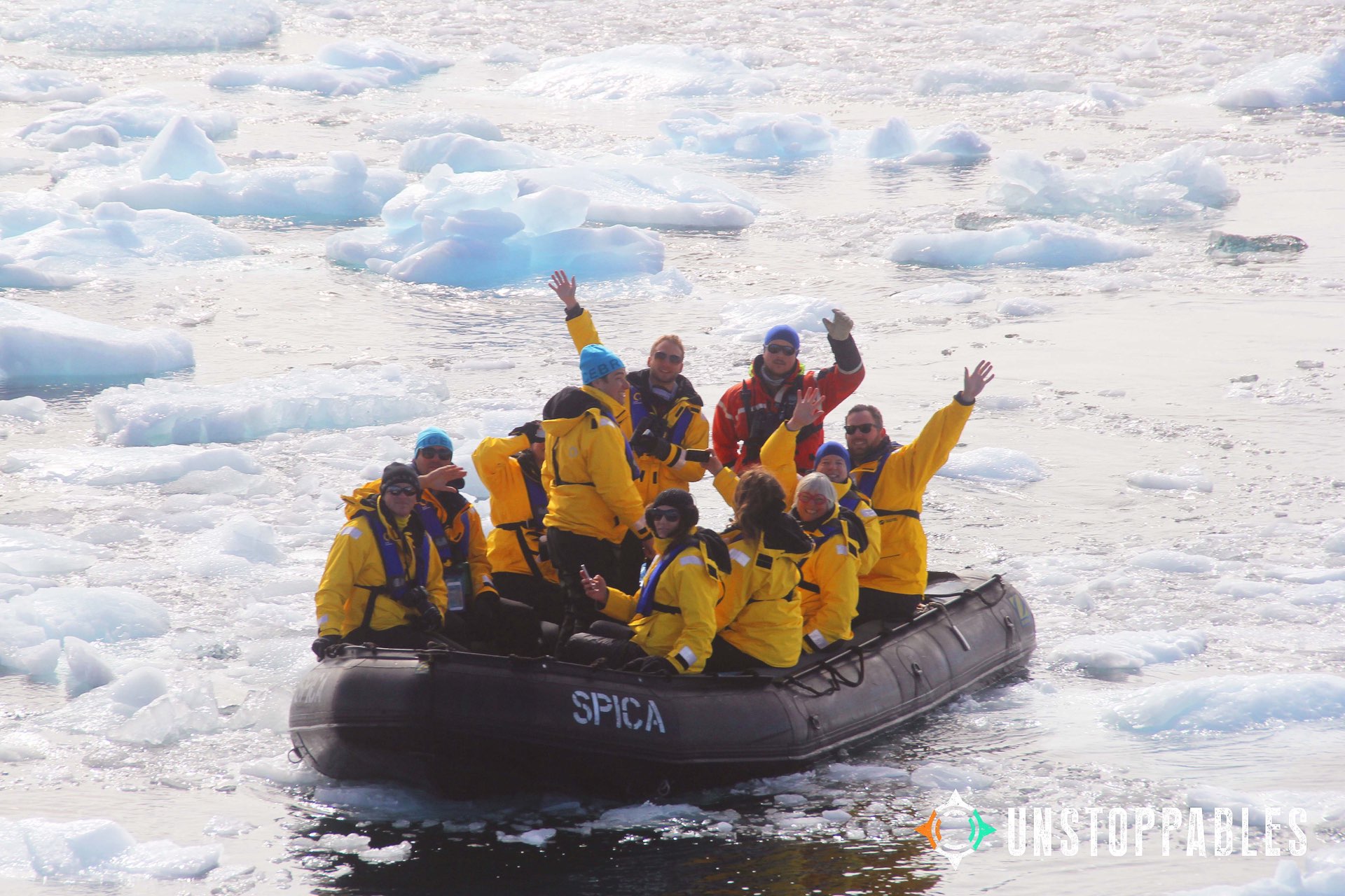 Unstoppables waving from a zodiac among the Antarctic sea ice
